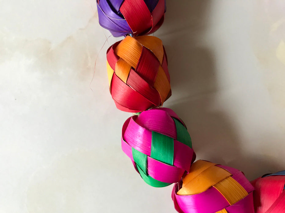 Mexico 1492: Traditional colorful Mexican Christmas decoration, a garland hand made of palm leaves in Guerrero. It can adorn a Christmas tree, or be piled up on a plate or in a fruit bowl to add a pop of color on a shelf or a table. 3.4m (11ft) long. 