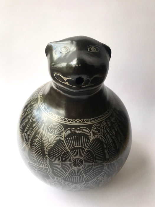 Mexico 1492: A jaguar shaped pitcher (called “cántaro” in Mexico), hand made, hand painted, carefully burnished using the river stones and finished in a fire. The jaguar motif is frequently found in Mexican mythology and ethnic arts, but this one is especially carefully created, and thoughtfully adorned with natural elements like flowers, birds, rain and wings. Used for storing liquids, like water or wine. 
