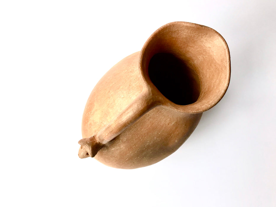 Mexico 1492: Stunning pitcher with an animal head ornament, made from red clay with a yellowish and gray tone and marked with random flame spots, adding character. Best for serving water, refreshing drinks, or even as a vase. Lead free, unglazed. Thanks to the artisanal nature of this handmade product, no two pieces are the same. 