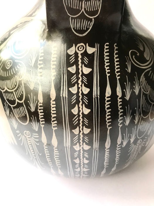 Mexico 1492: A jaguar shaped pitcher (called “cántaro” in Mexico), hand made, hand painted, carefully burnished using the river stones and finished in a fire. The jaguar motif is frequently found in Mexican mythology and ethnic arts, but this one is especially carefully created, and thoughtfully adorned with natural elements like flowers, birds, rain and wings. Used for storing liquids, like water or wine. 