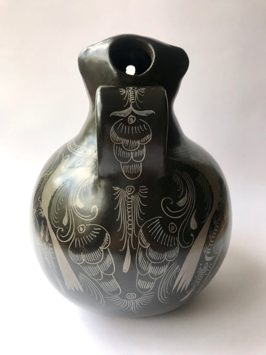 Mexico 1492: A jaguar shaped pitcher (called “cántaro” in Mexico), hand made, hand painted, carefully burnished using the river stones and finished in a fire. The jaguar motif is frequently found in Mexican mythology and ethnic arts, but this one is especially carefully created, and thoughtfully adorned with natural elements like flowers, birds, rain and wings. Used for storing liquids, like water or wine. 