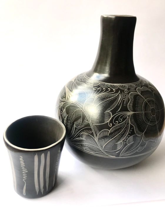 Mexico 1492: The black “cántaro” (pitcher), hand made out of clay, hand painted with birds, flowers and leaves, and burnished to shine. Accompanied by a matching glass. Used for storing liquids, like water or wine.   “Cántaro” is a precious piece in every Mexican home, and a favorite way to store water. It is believed that water stays cool in a “cántaro” even on a hottest day.