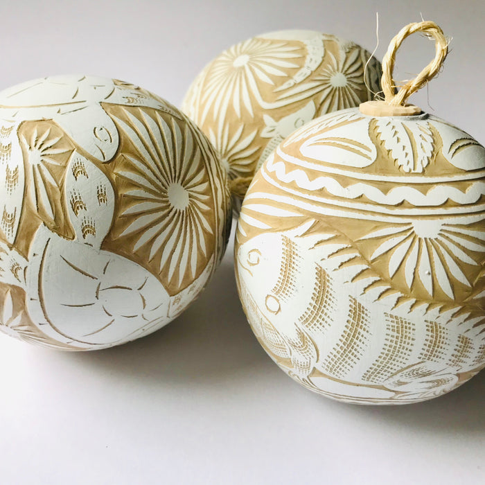 Mexico 1492 - Large, carved, round gourd sphere (guaje), dyed in white and carved by the skillful hands of the Oaxacan artisans. Looks spectacular on a Christmas tree and breathtaking in a pack of 12 or more on a plate or in a bowl. Carved with motifs of birds, armadillos, iguanas and sea turtles. 
