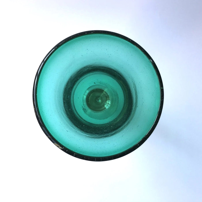 Mexico 1492: Shaped like a colored bell, with a transparent stem and foot, and hundreds of air bubbles reflecting the light, these classic wine glasses are a centerpiece and a conversation starter. Hand made with care, reflecting decades of traditional Mexican glass factories.  Available in Amethyst Purple, Turquoise, Fire Red, Cobalt Blue, Emerald Green, Lime Green and Smoke. 