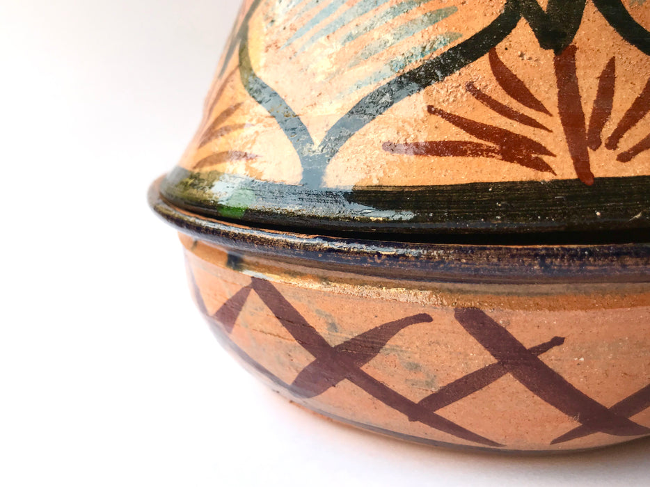 Mexico 1492: What happens when a traditional Morroccan clay dish gets transformed by warm, colorful, unstoppable Mexican creativity? Don Abel y doña Matea created a cultural fusion of Mexico and North Africa, so beautiful and imaginative. Traditional tajine, the predecessor of the modern crock pot, embellished by the talent and skill of the amazing Oaxacan artisans. Handmade, painted and lead-free glazed in Oaxaca, Mexico. Version: Black Agave.