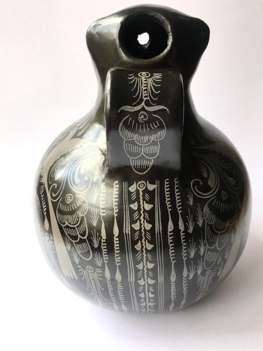 Mexico 1492: A jaguar shaped pitcher (called “cántaro” in Mexico), hand made, hand painted, carefully burnished using the river stones and finished in a fire. The jaguar motif is frequently found in Mexican mythology and ethnic arts, but this one is especially carefully created, and thoughtfully adorned with natural elements like flowers, birds, rain and wings. Used for storing liquids, like water or wine. 