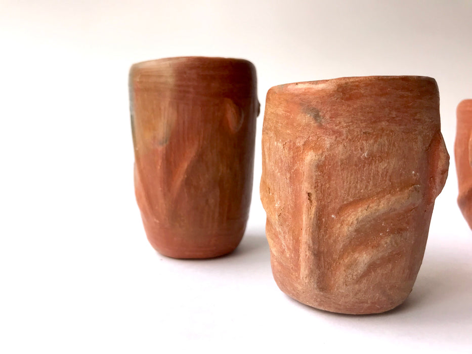 Mexico 1492: Stunning shot glasses with Zapotec profile-shaped ornaments, made from red clay and marked with random flame spots, adding character. Excellent for serving tequila or mezcal. Lead free, unglazed. Thanks to the handmade nature and the flame marks, no two pieces are the same, or even of the same height, which adds a lot of charm and informality. 